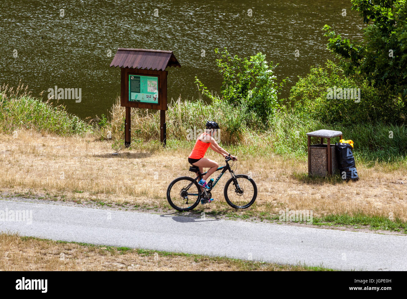 Junge Frau, die auf einem Radweg entlang des Flusses Berounka, Tschechien, radeln Europa Stockfoto