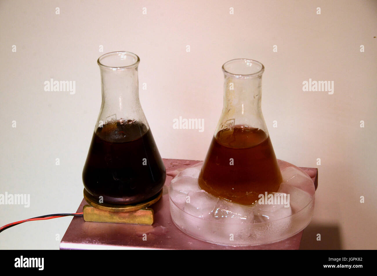 Chemische Reaktionsgeschwindigkeit gegen die Temperatur: eine chemische Reaktion macht eine flüssige ändern der Farbe schwarz. Die linken Flasche ist leicht, die richtigen Bo beheizt. Stockfoto