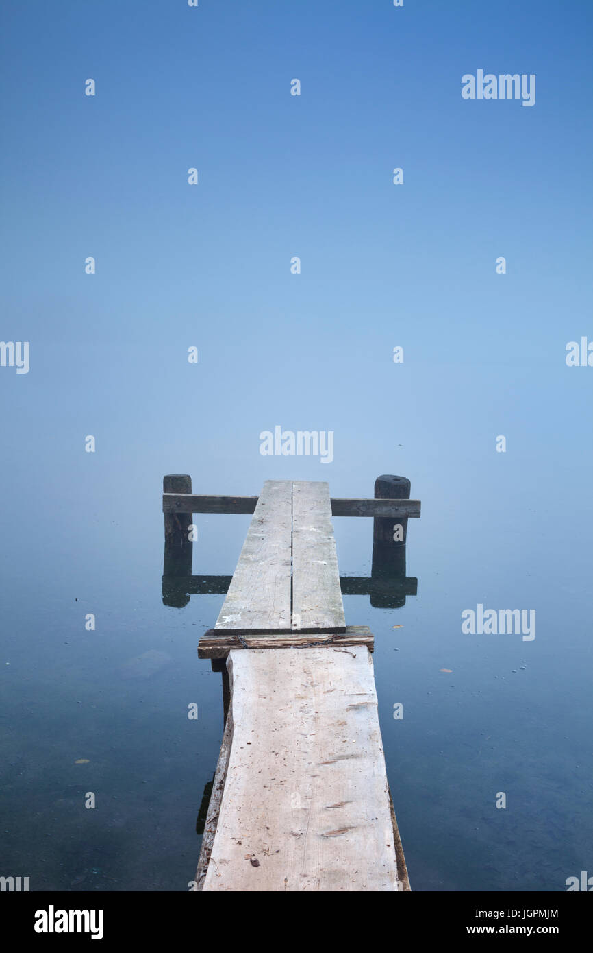 Ein kleiner Steg am Bohinj See in Slowenien an einem nebligen Morgen. Stockfoto