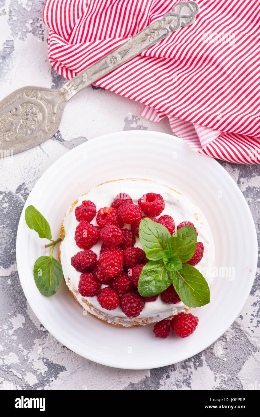 Kuchen mit Himbeeren und Sahne auf einem Tisch Stockfoto