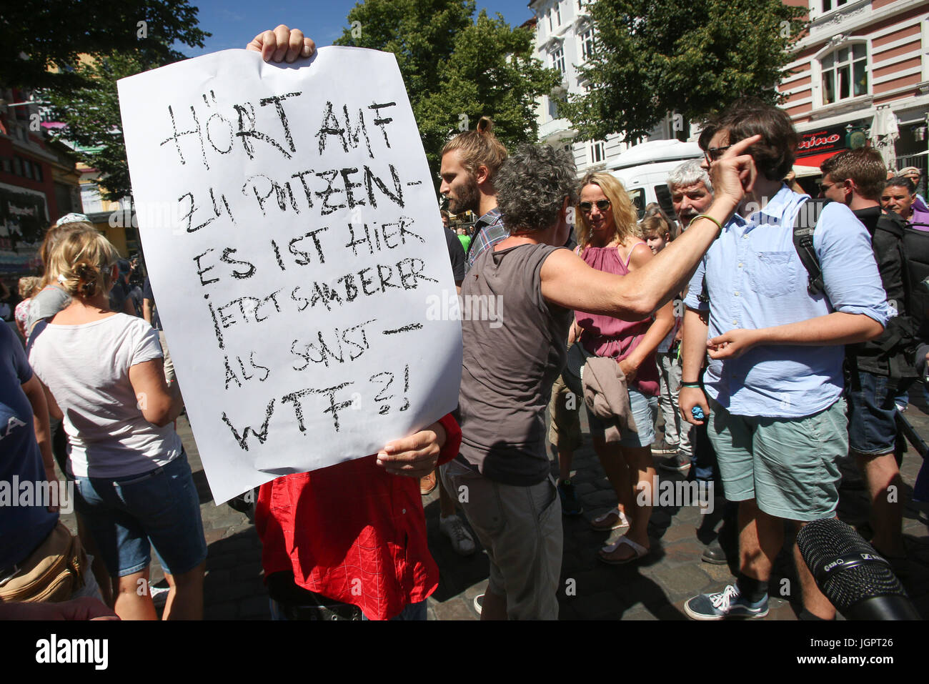 Dpatop - besprechen Sie Teilnehmer einer Reinigung Kampagne mit Menschen, die gegen die Reinigung vor der Roten Flora-Kulturzentrum in Hamburg, Deutschland, 9. Juli 2017 scheinen. Ein Mann hält ein Schild mit der Aufschrift "Hoert Auf Zu Putzen - Es ist Hier Jetzt Sauberer als Sonst - Wtf?!" (lit.) "Hör auf die Reinigung – jetzt ist es sauberer als sonst - Wtf?! (Was zum Teufel?! "). Eine Frau aus Hamburg mobilisiert mehrere tausend Menschen über Facebook um das Schanzenviertel Distrtict und in anderen Bereichen der Stadt zu bereinigen. Während des G20-Gipfels in Hamburg verwüstet Demonstranten Teil der Stadt, vor allem der Schanze Stockfoto