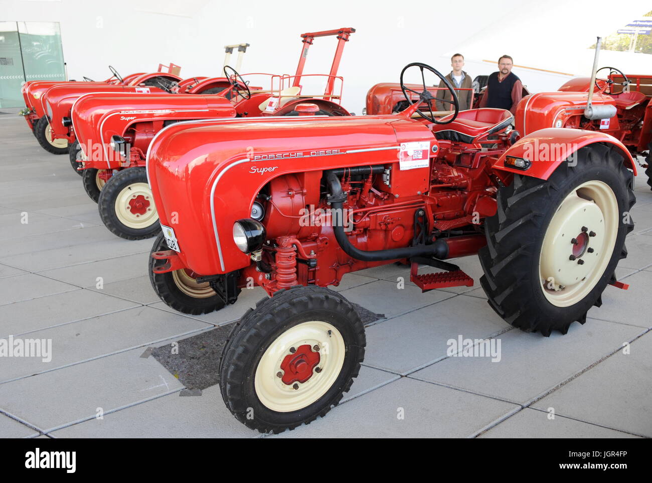 Stuttgart-Zuffenhausen, Deutschland. 24. April 2010. Besucher bestaunen Sie historische Traktoren im Porschemuseum in Stuttgart-Zuffenhausen, Deutschland, 24. April 2010. 39 Privatbesitz Traktoren, entwickelt und gebaut von Porsche zwischen 1950 und 1963 werden im Rahmen einer Open-Air-Ausstellung gezeigt. Porsche-Diesel Traktoren gehören zu den erfolgreichsten landwirtschaftlichen Fahrzeugen mit insgesamt 120 000 Exemplare. Foto: BERND WEISSBROD | weltweite Nutzung/Dpa/Alamy Live-Nachrichten Stockfoto