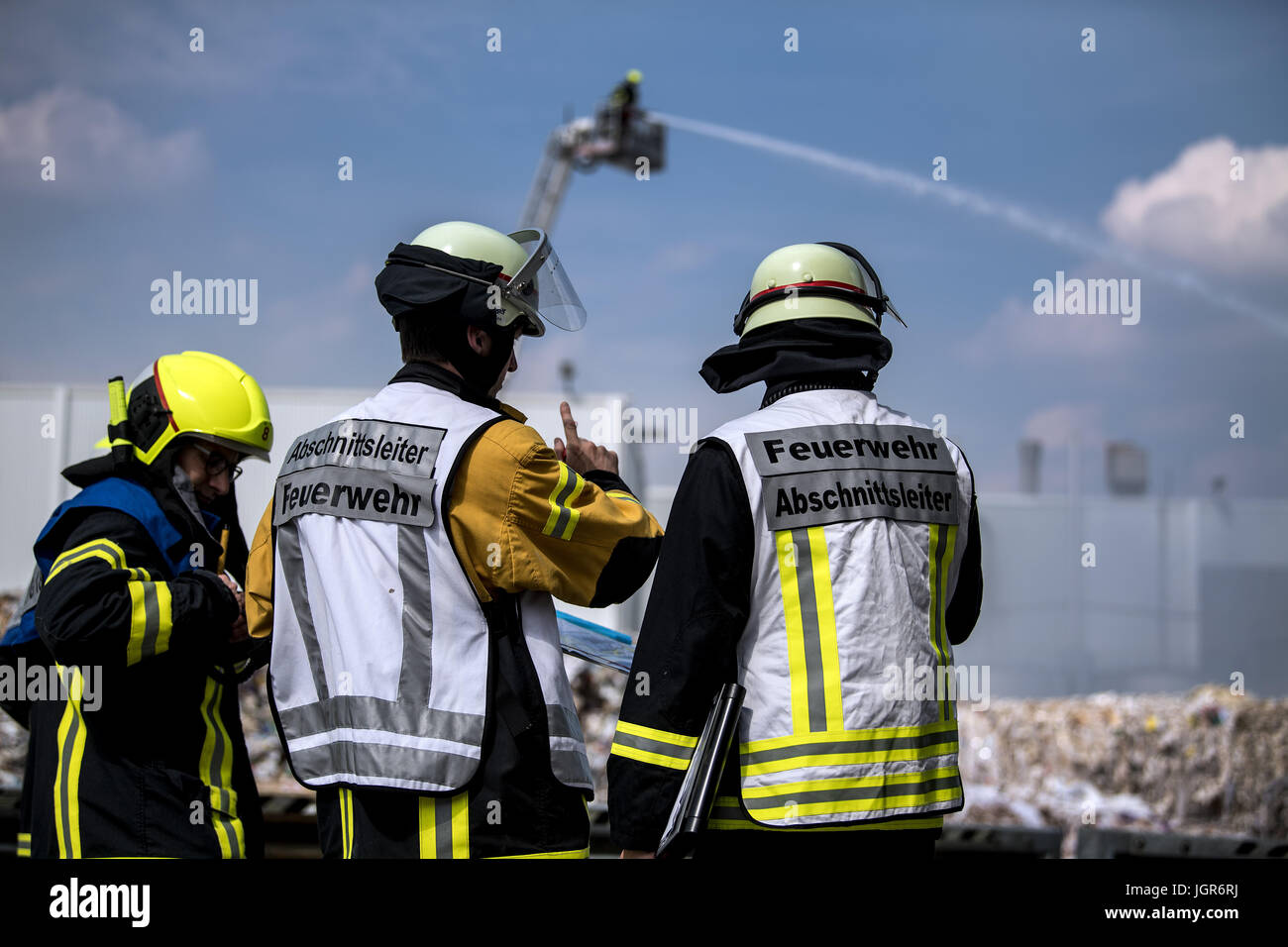 Feuerwehrleute löschen einen Brand in einem Papier Laden in Neuss, Deutschland, 7. Juli 2017. Ein großes Feuer brach an einem externen Speicher einer Papierfabrik in Neuss Hafen. Foto: Federico Gambarini/dpa Stockfoto