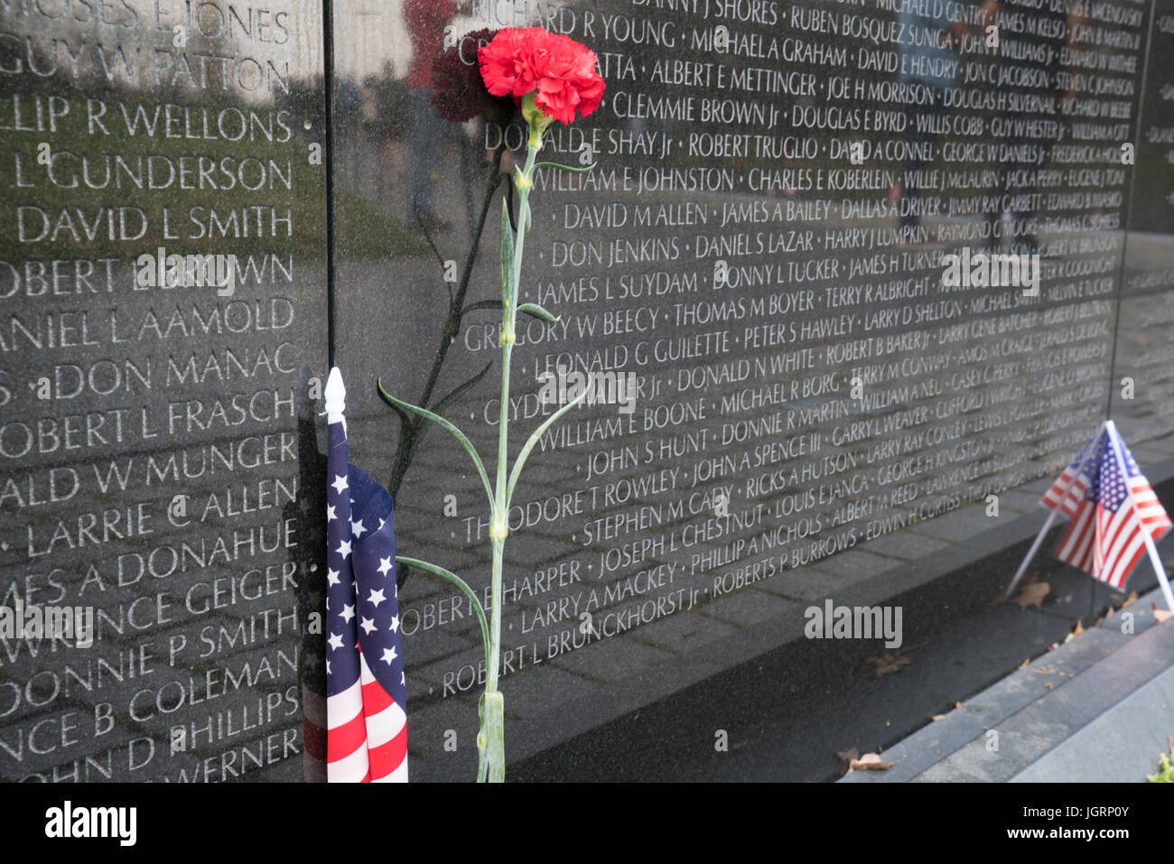WASHINGTON, DC - März 2016: Lone rote Nelke und amerikanische Flagge am Vietnam Veterans Memorial Stockfoto