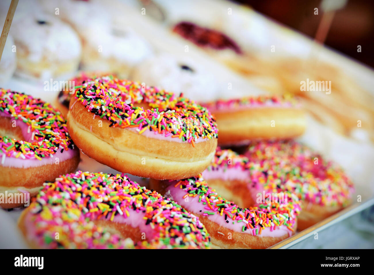 Hausgemachte bunte Donuts mit Schokolade und Zuckerguss Glasur, süß Puderzucker Zucker essen Stockfoto