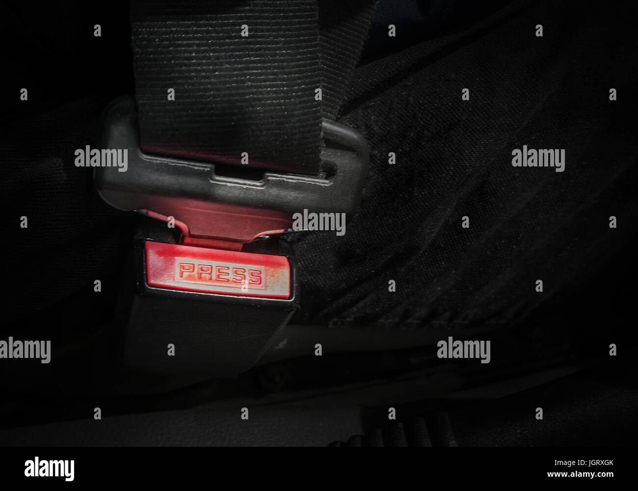 Auto-Sicherheitsgurt zu sperren. Roten Knopf aus den Sicherheitsgurt im Auto auf einem schwarzen Hintergrund. Stockfoto
