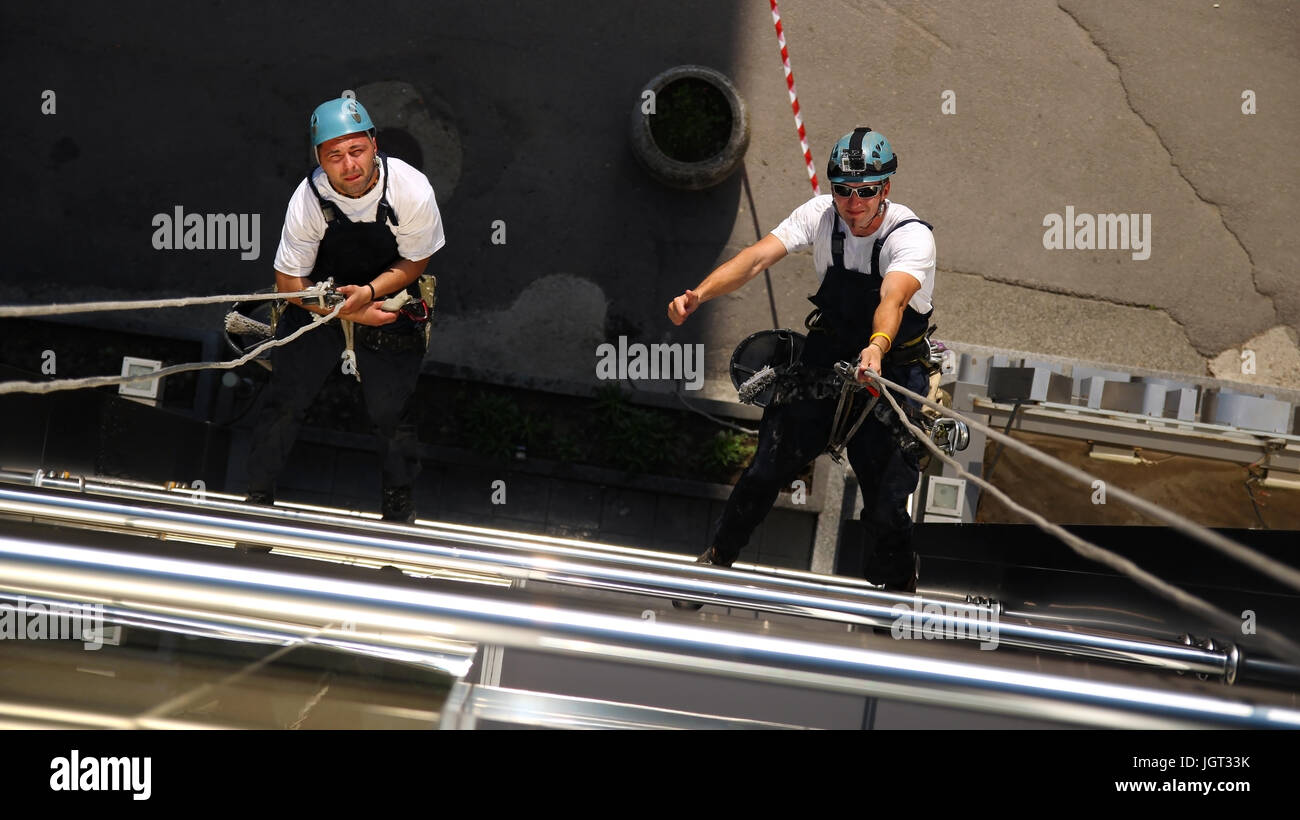 Arbeiter an Kletterseilen, hängen Daumen Schild zeigt. Stockfoto