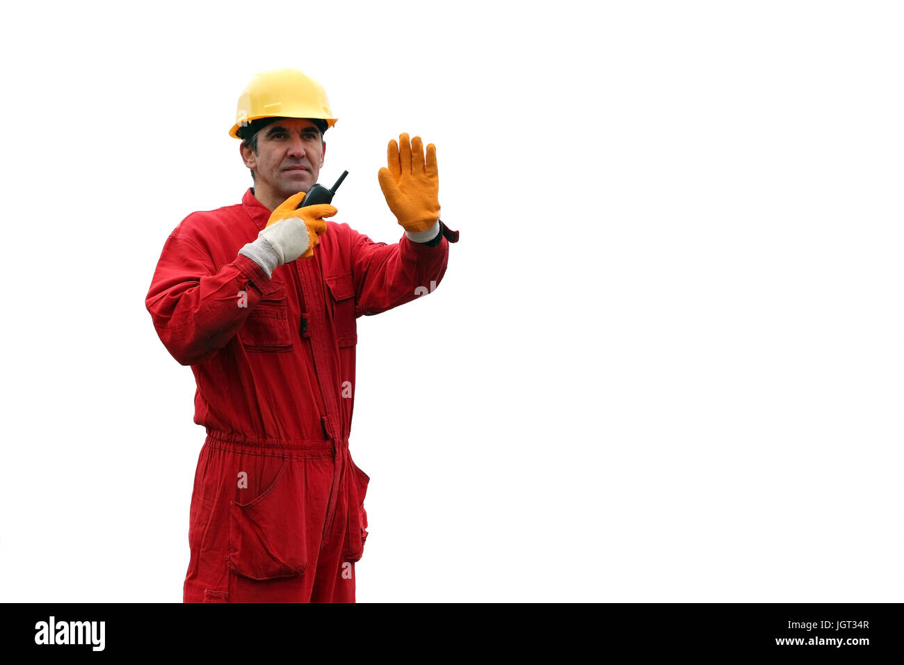 Ein Portrait eines Arbeitnehmers im roten Overall und gelben Helm mit Walkie-talkie. Stockfoto