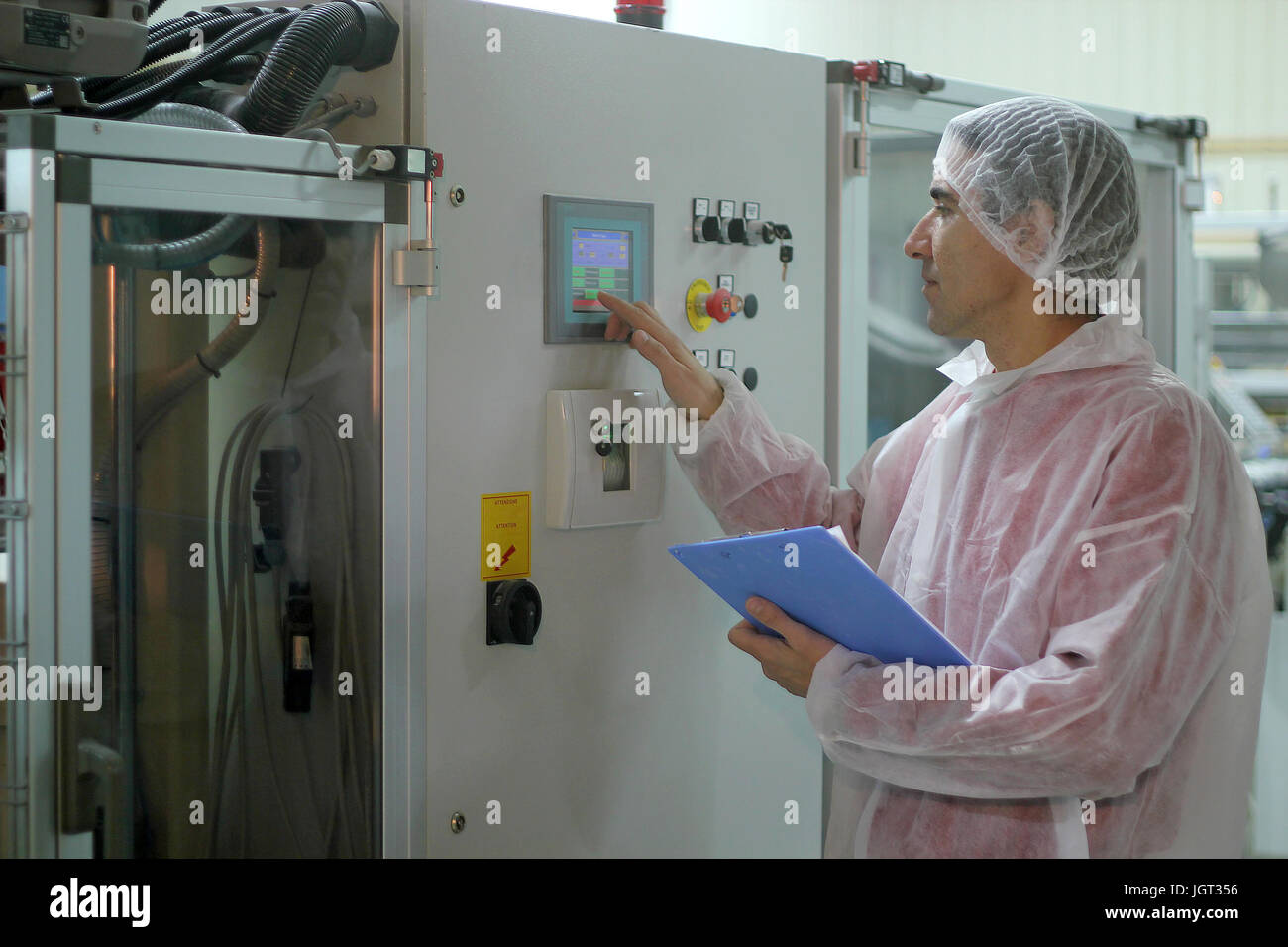 Arbeitnehmer über die Systemsteuerung der industriellen Maschine. Stockfoto