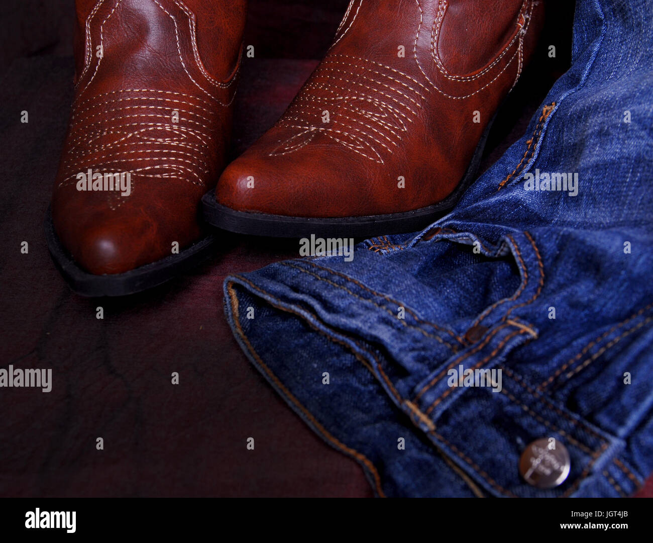 Western-Look, blaue Jeans und Cowboystiefeln. Stockfoto