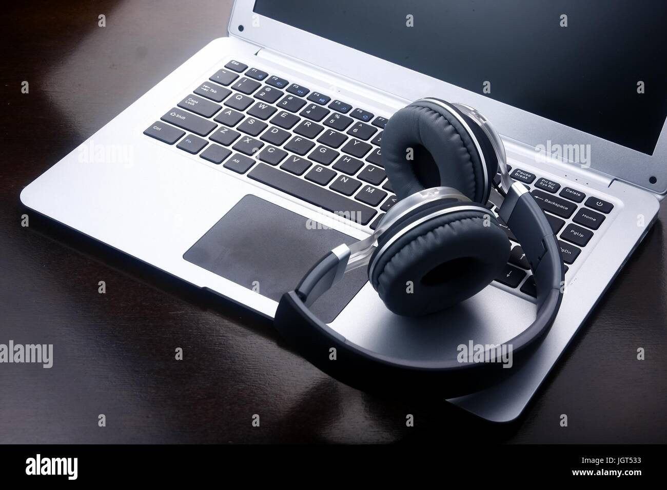 Foto von Kopfhörern auf einem Laptop-Computer-Tastatur. Stockfoto