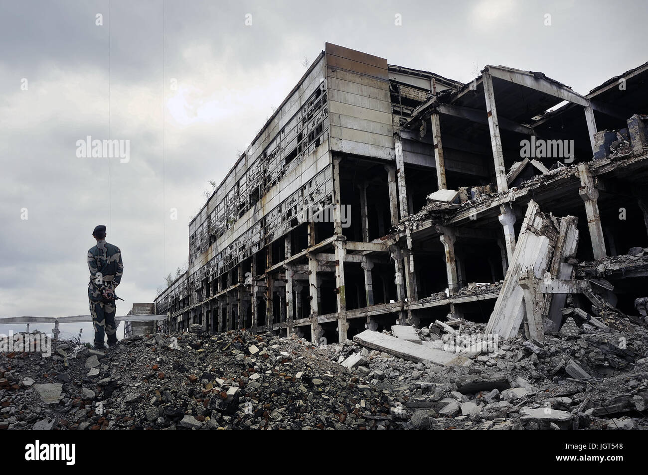 Soldat in Militäruniform steht auf den Ruinen des zerstörten Hauses. Hot Spots auf dem Planeten. Das Konzept des Kampfes gegen den Terrorismus. Stockfoto