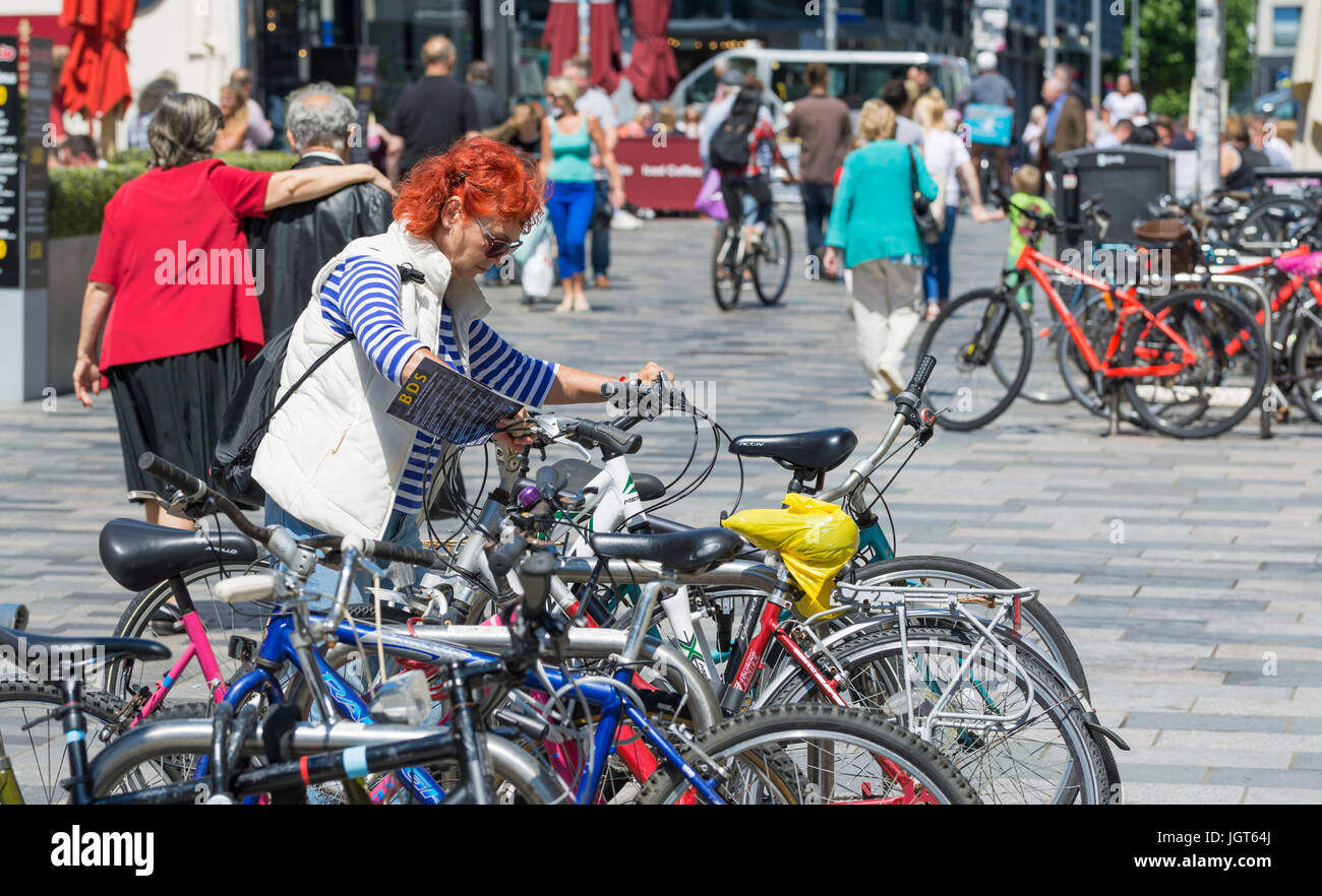 Frau sperren ihr Fahrrad zu halten in einer Stadt gestohlen werden. Stockfoto