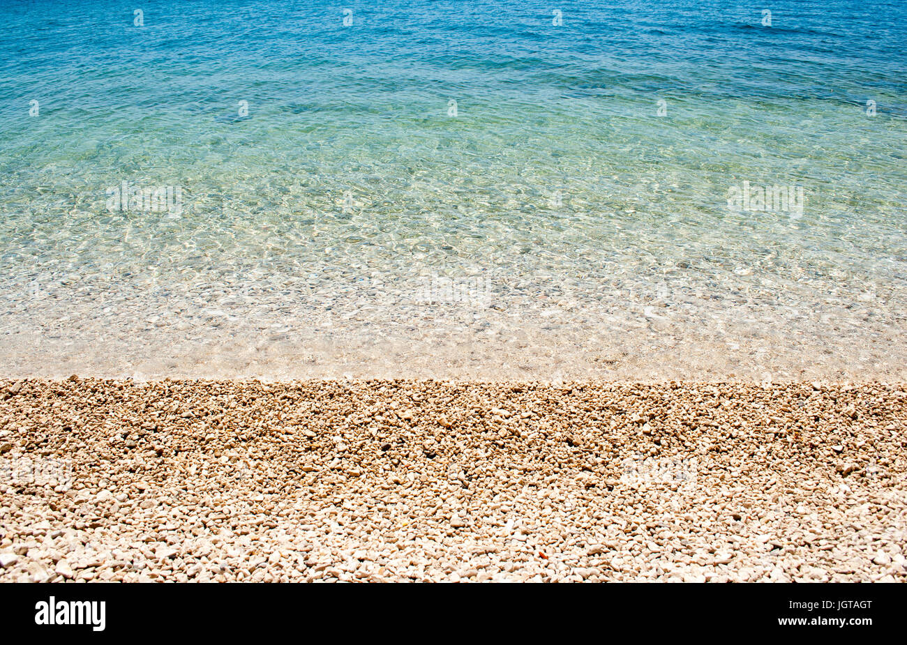 Horizontale Hintergrund Bild der ruhigen türkisfarbenen Meer mit Kieselstrand Stockfoto