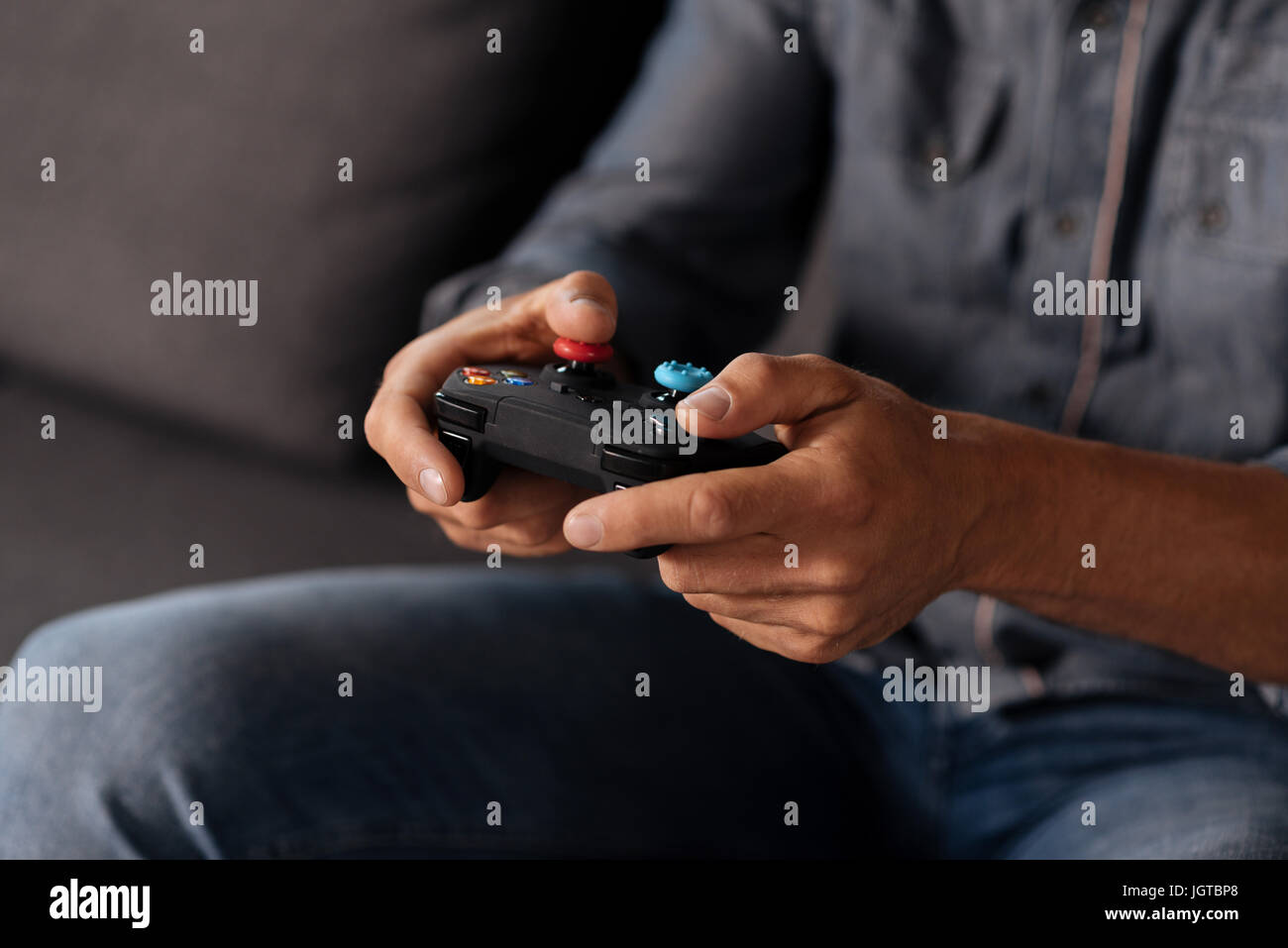 Sorgfältige schnelles witted Mann hält Gaming-Zubehör Stockfoto