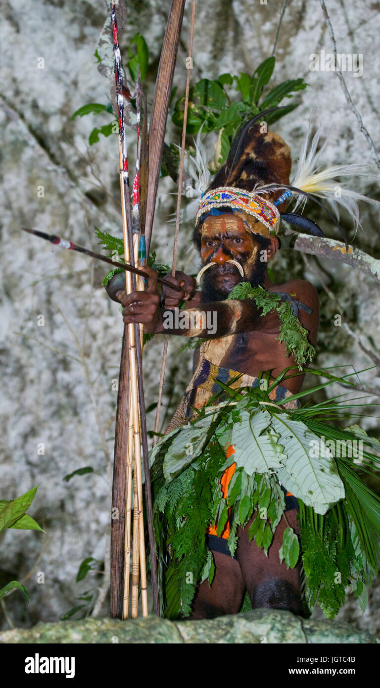 Neuguinea, Indonesien - 13 Januar: Krieger Stamm Yaffi in Kriegsbemalung mit Pfeil und Bogen in der Höhle. Neue Insel Guinea, Indonesien. Stockfoto