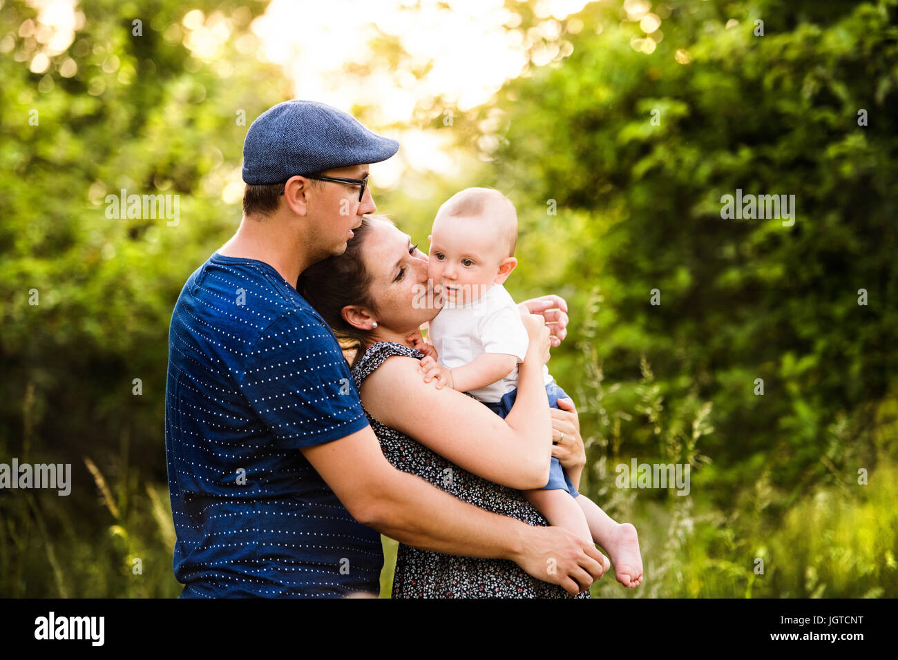 Junge Familie mit kleinen Sohn im sonnigen Sommer-Natur Stockfoto