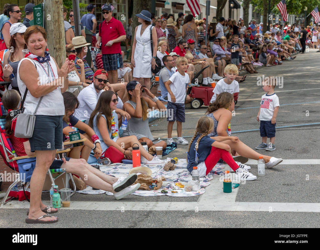 große Gruppe von Menschen sitzen und stehen auf der Hauptstraße, eine Parade in Southampton, New York zu sehen Stockfoto