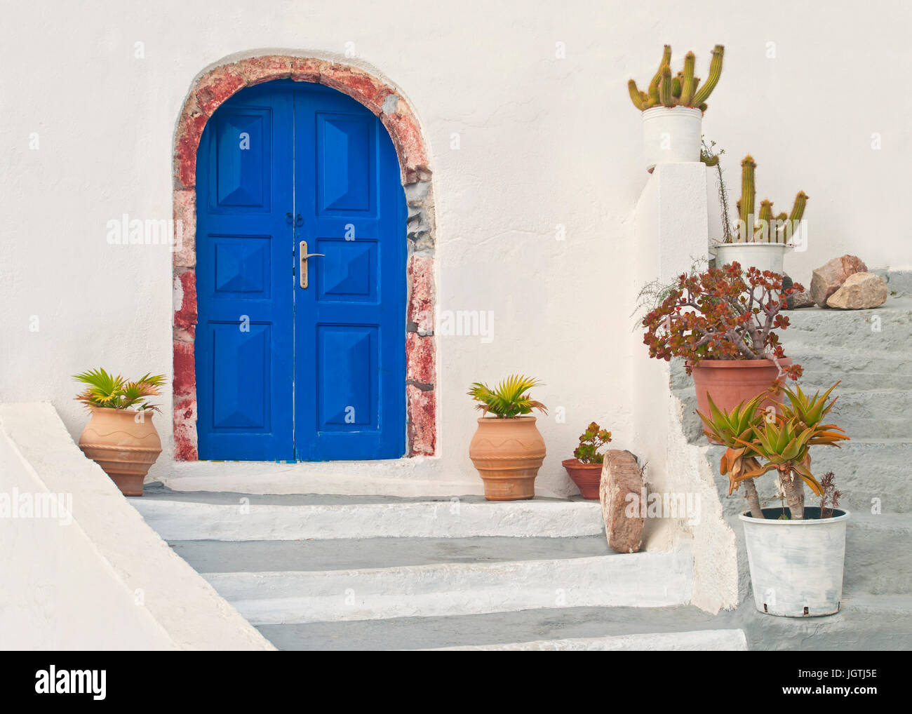 blaue Tür des schönen weißen griechischen Haus mit Blumentöpfen auf Treppen in Stadt Oia, Santorini (Thira), Griechenland Stockfoto