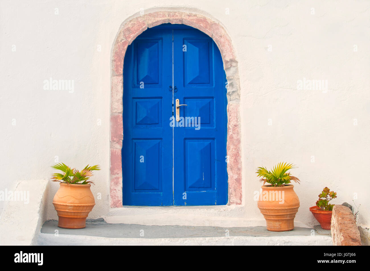 traditionelle griechische weißen Hausfassade mit blauen Tür und Blumentöpfe, Santorini, Griechenland Stockfoto