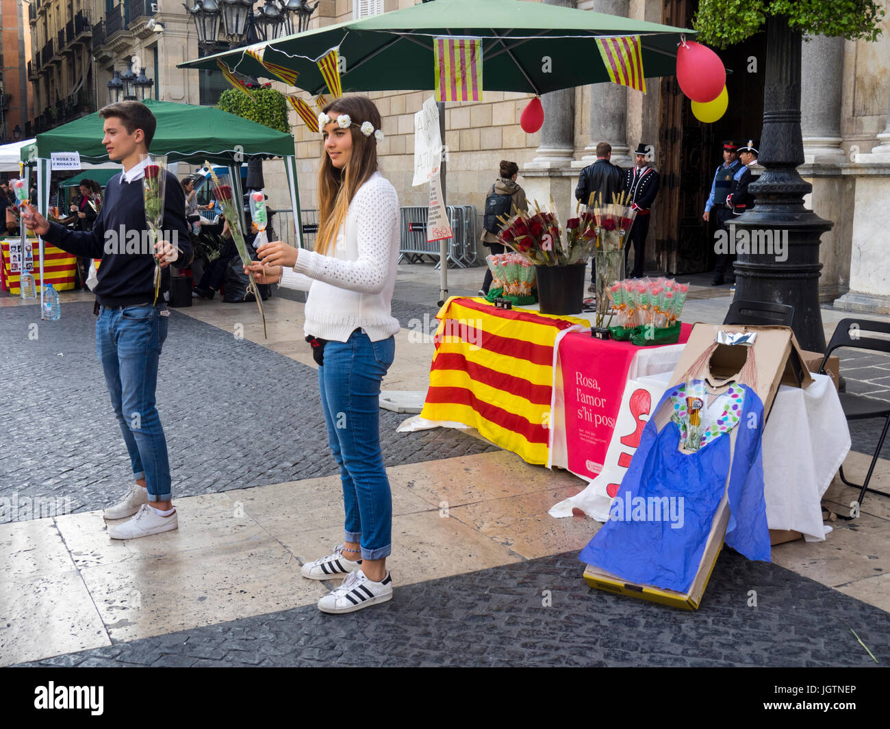 Ein junger Mann und Frau verkaufen rote Rosen auf Sant Jordi Tag, Barcelona, Spanien. Stockfoto