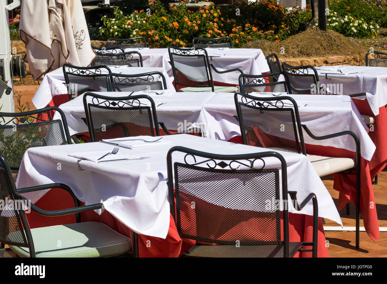 Leere Tische mit weißen Tischdecken. – Ein Meer Restaurant Set für Mittagessen: Baia Sardinien, Gallura, Sardinien, Italien. Stockfoto