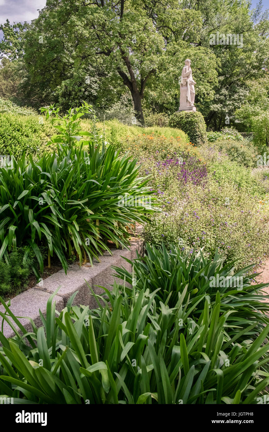 Pflanzen und Statue im königlichen botanischen Garten, Madrid, Spanien (Real Jardin Botanico). Stockfoto
