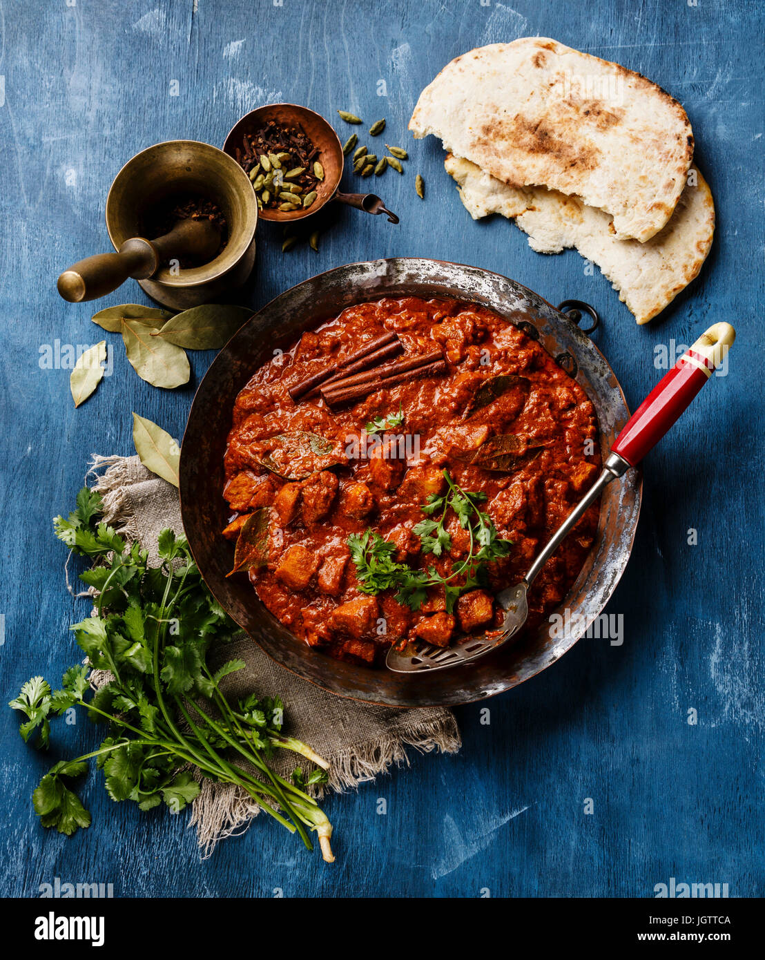 Chicken Tikka Masala würzigen indischen curry in einem kupfernen Topf auf blauem Hintergrund aus Holz Stockfoto