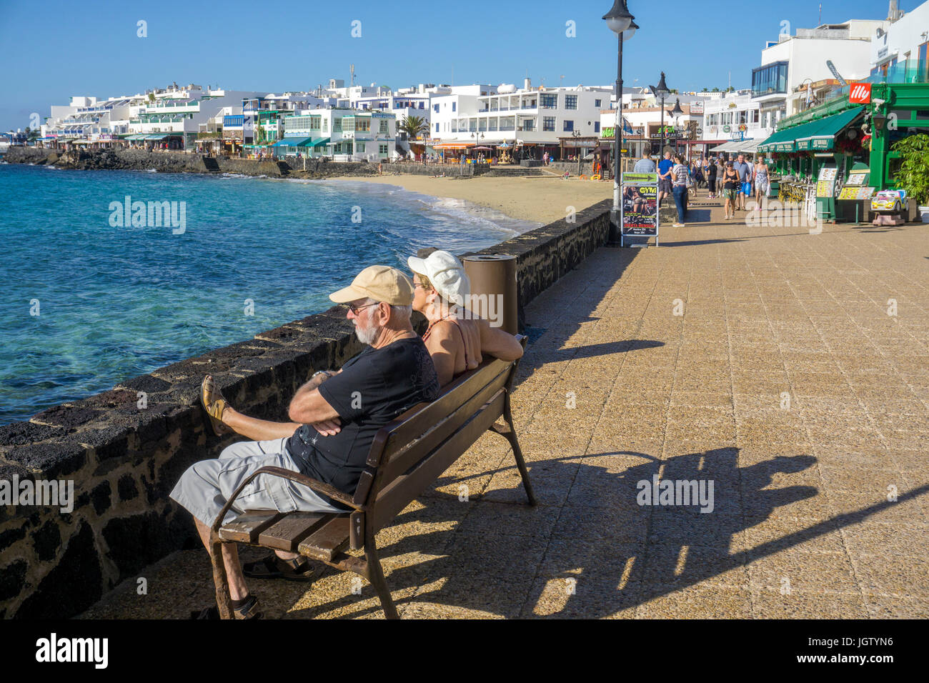 Alte Paar auf einer Bank, Promenade an der Waterfront, Playa Blanca, Insel Lanzarote, Kanarische Inseln, Spanien, Europa Stockfoto