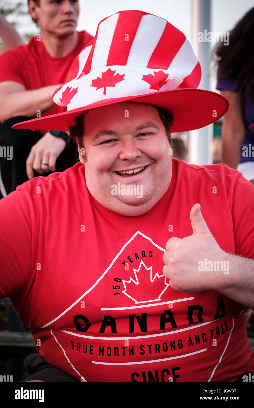 Mann in den kanadischen Farben, der die Daumen hoch gibt, lächelt an der Kamera, Kanadas 150. Geburtstag, die Feier des Canada Day, eine Show des Patriotismus. Stockfoto