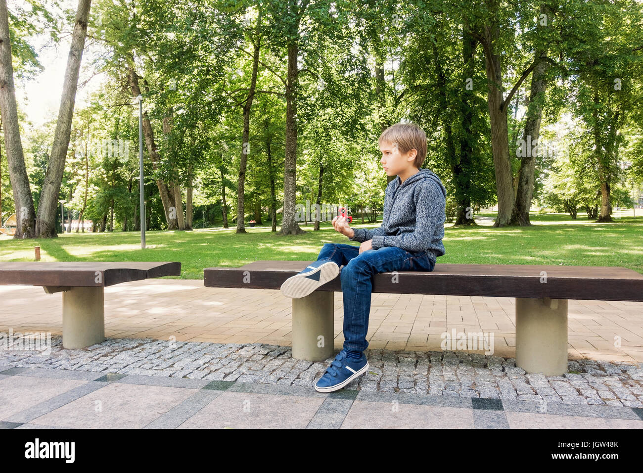 Kind spielt mit Spinner allein im freien Stockfoto