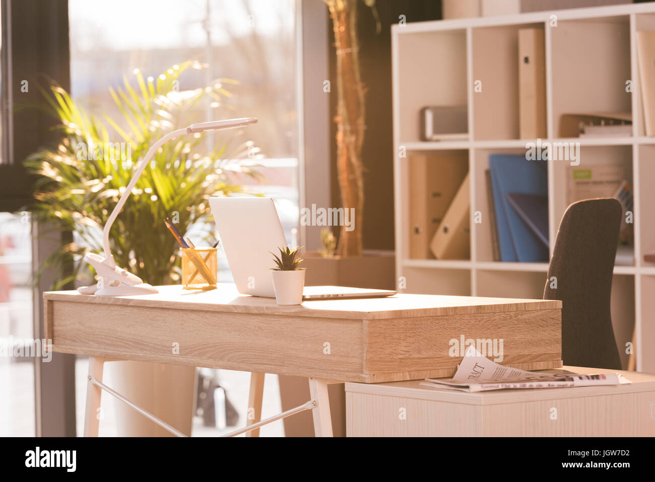 Arbeitsbereich mit Laptop-Computer in modernen leeren Büro mit Sonnenlicht Stockfoto