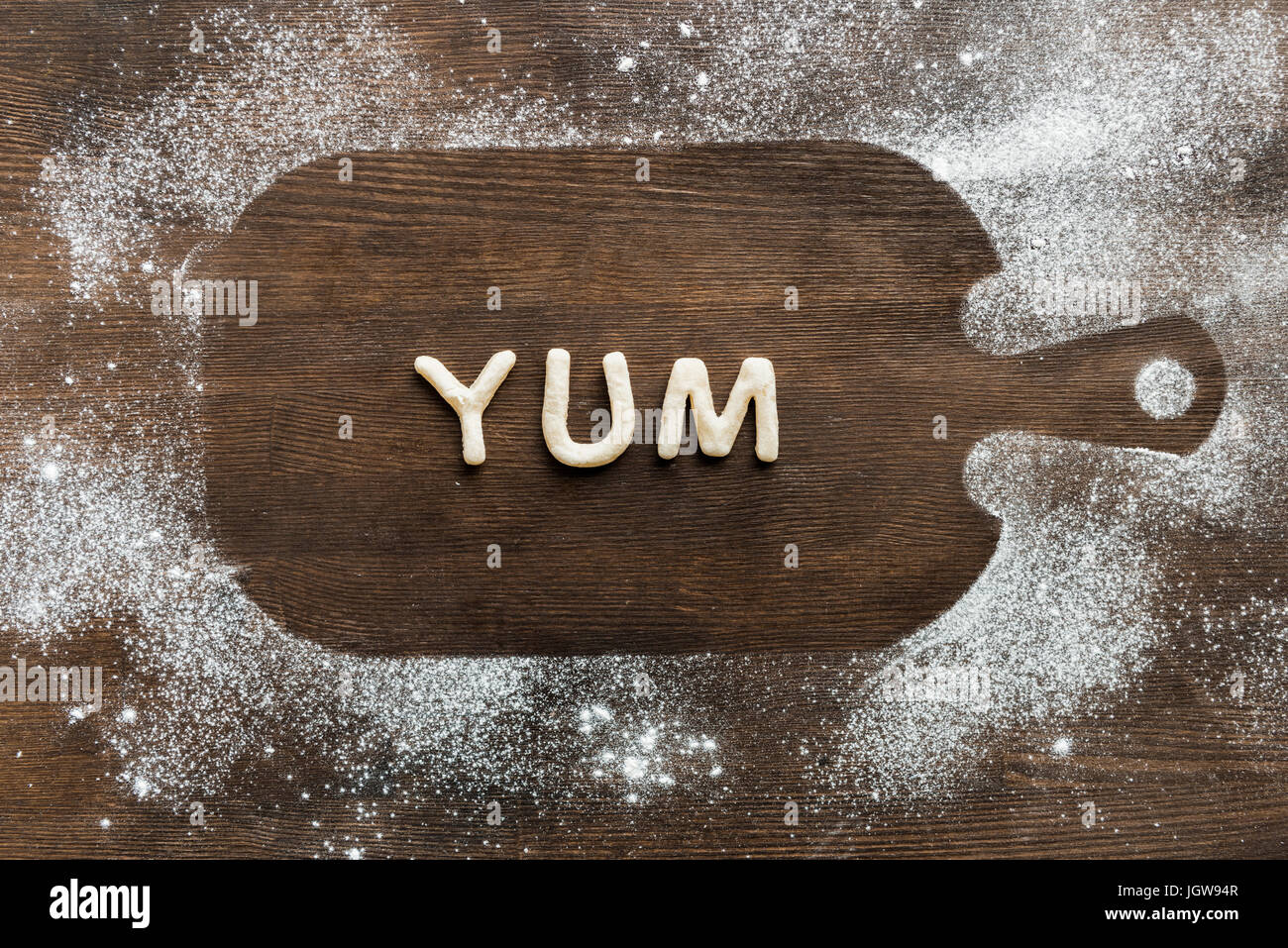 Draufsicht der essbaren Schriftzug Yum hergestellt aus Cookies auf Holzbrett, Backen Cookies Konzept Stockfoto