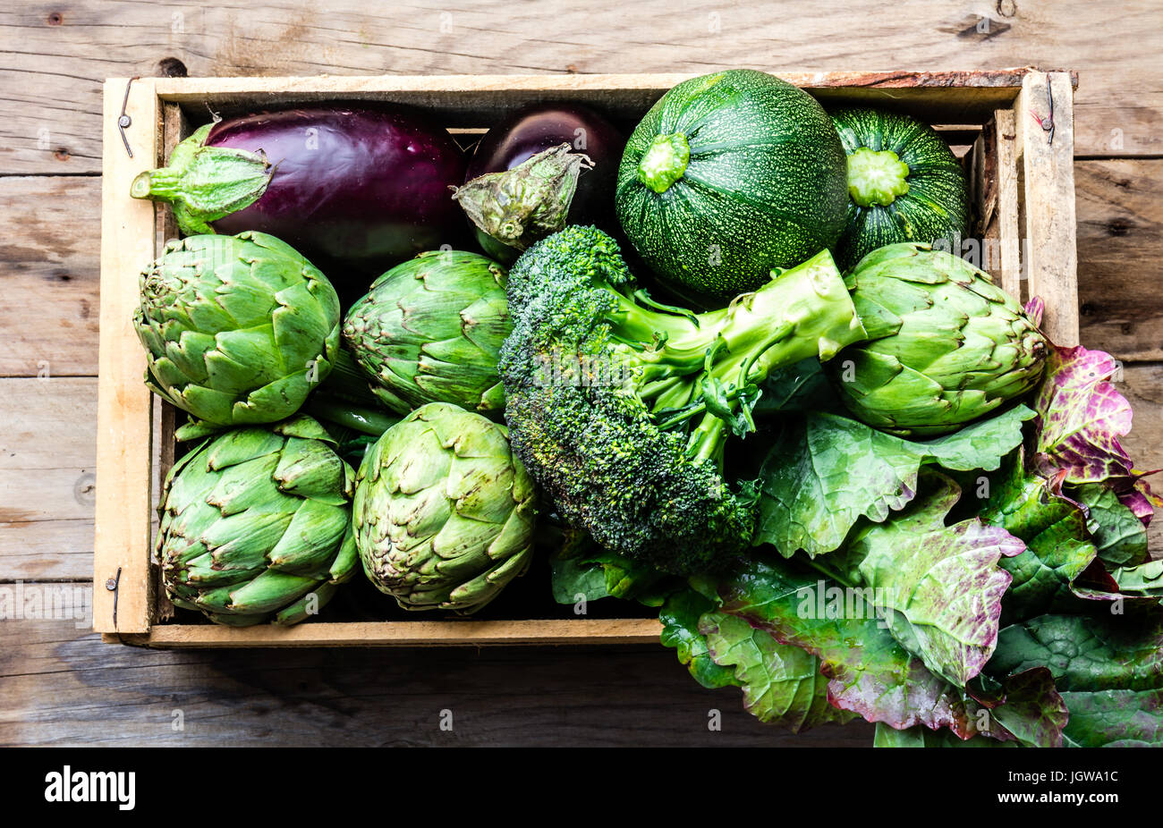 Kochen Hintergrund Ernte Konzept. Frische organische grünes Gemüse in Holzkiste Stockfoto