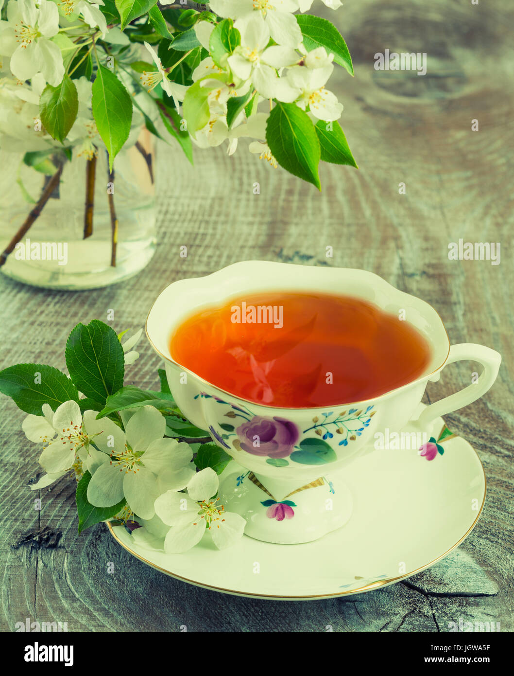 Tasse Tee und Apfel Baum Blumen Blumenstrauß getönt Stockfoto
