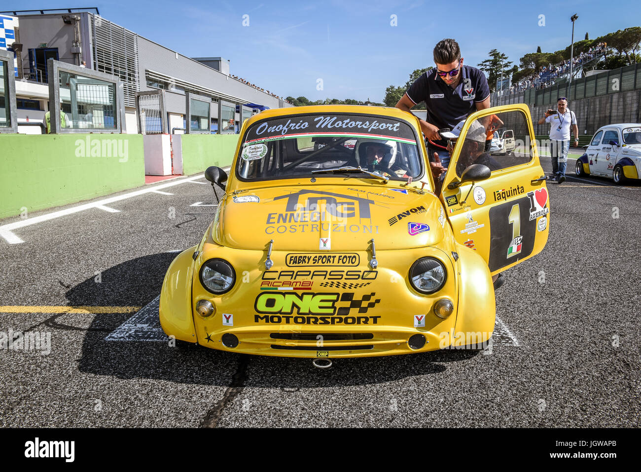 Italienische Bicilindriche Cup, gelben Fiat 500 Rennwagen auf der Startaufstellung mit Mechaniker Stockfoto