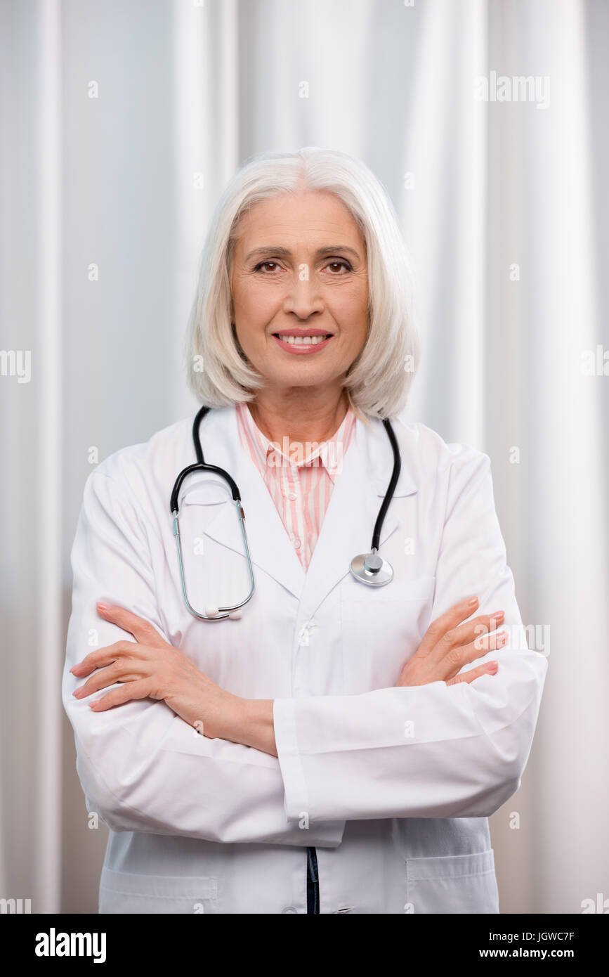 Porträt von leitender Arzt mit Stethoskop und verschränkten Armen Blick in die Kamera Stockfoto