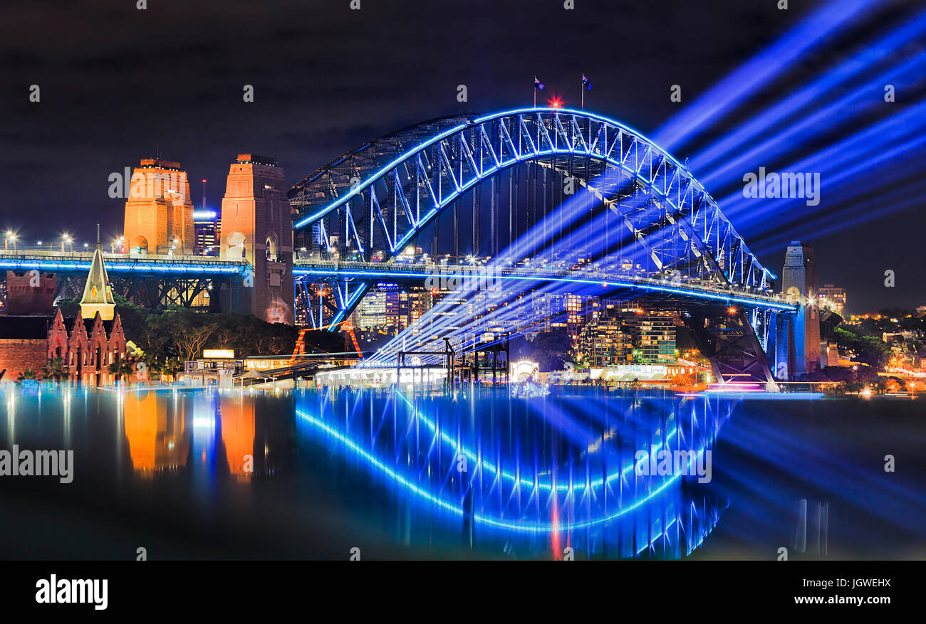 Sydney Hafen-Brücke bei vivid Sydney Lichterfest beleuchtet. Helle blaue Lichtstrahlen Projekt aus Übersee Passagierterminal in den Felsen-fr Stockfoto