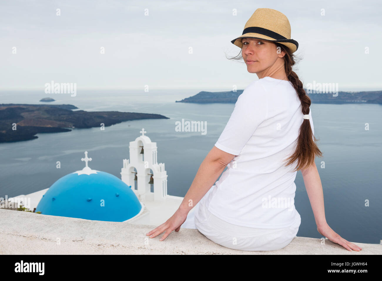 Junge Frau mit Agios Theodori Kirche und Glockenturm, Santorin, Griechenland Stockfoto