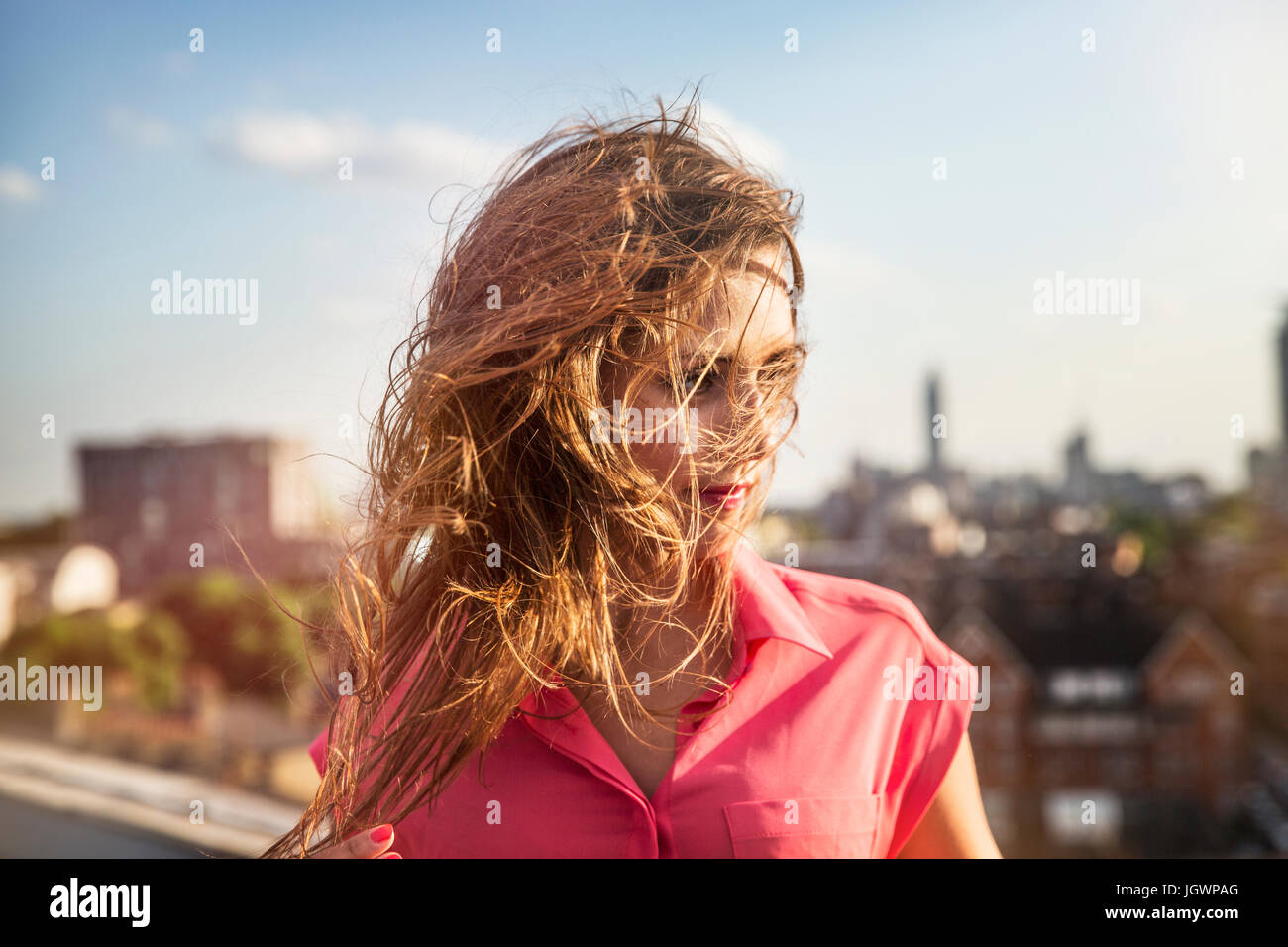 Junge Frau mit langen windigen Haar bei Dach-Party in London, UK Stockfoto