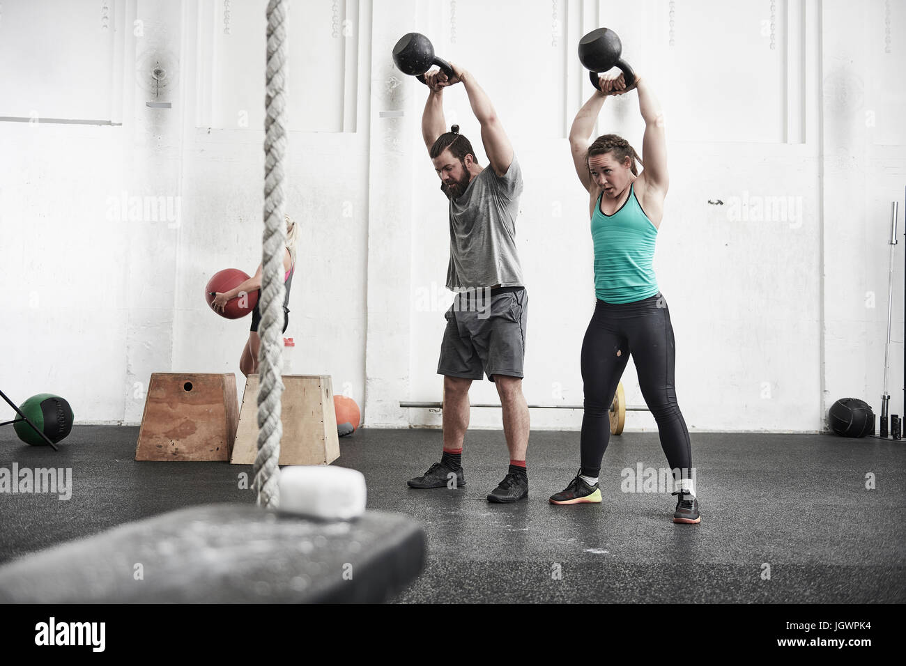 Paar mit Kettlebells in cross-training Fitness-Studio trainieren Stockfoto