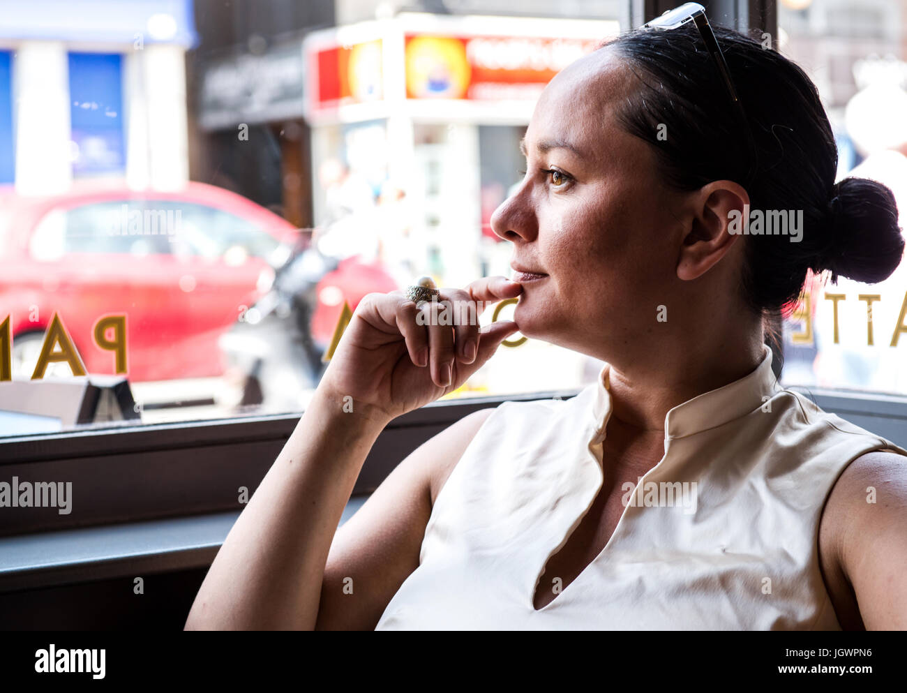 Geschäftsfrau mit Hand am Kinn in Café-bar Stockfoto
