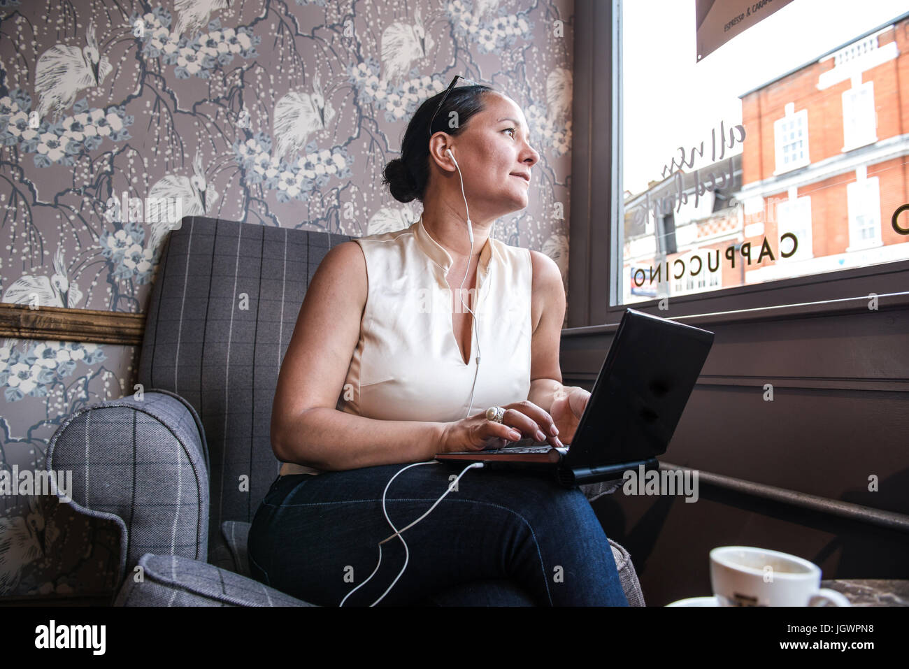 Geschäftsfrau in Kaffeebar Blick durch Fenster mit laptop Stockfoto
