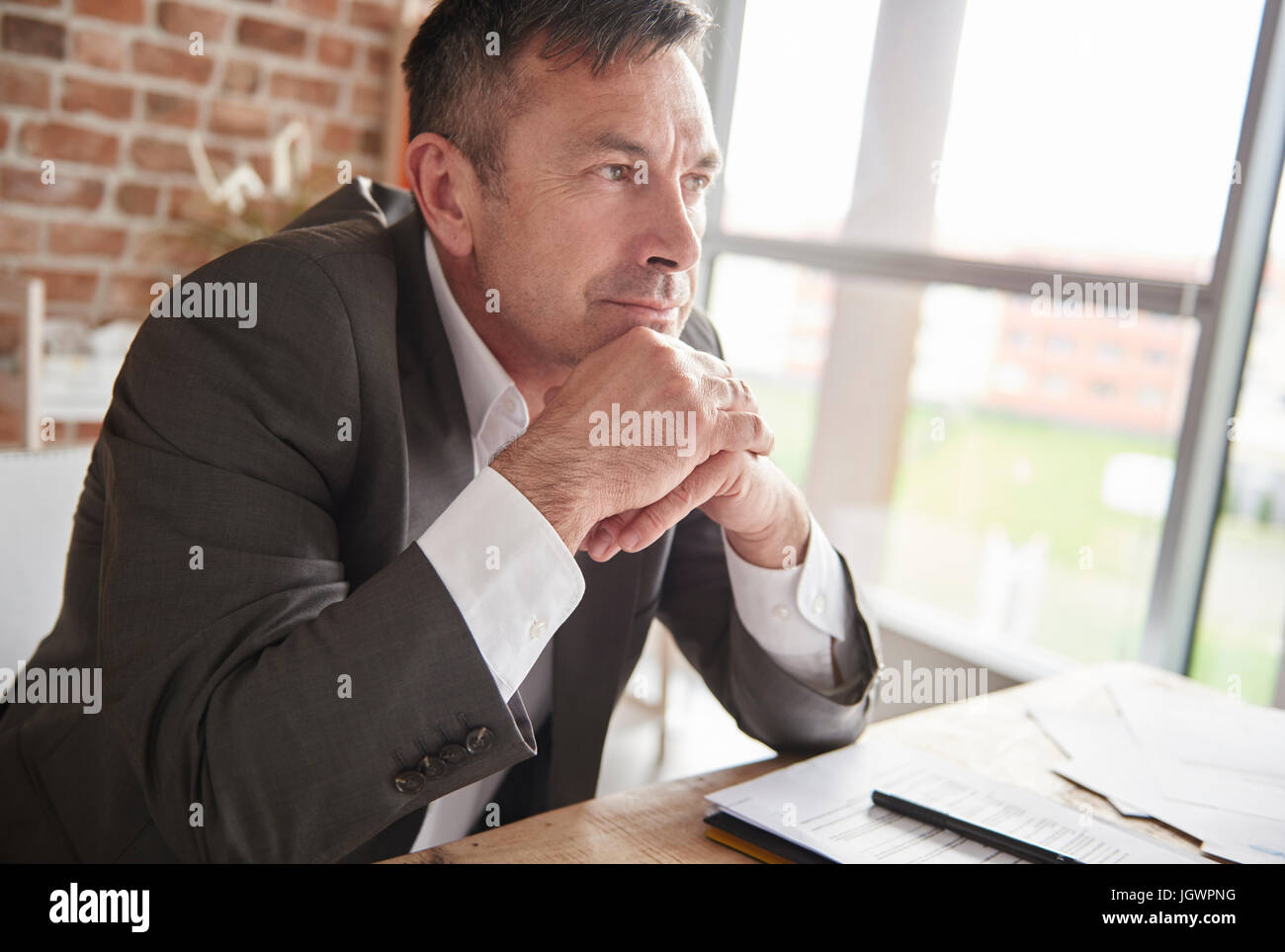 Porträt des Mannes mit den Händen auf Kinn wegschauen Stockfoto