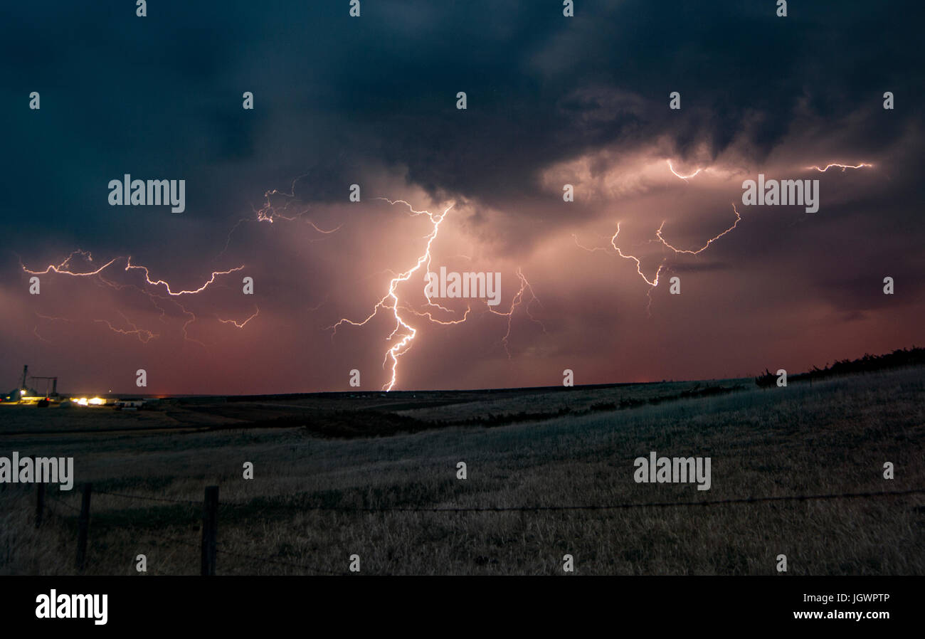 Forked Lightning in orangefarbenen Himmel über ländliche Gegend, Grant, Nebraska, USA, Nordamerika Stockfoto