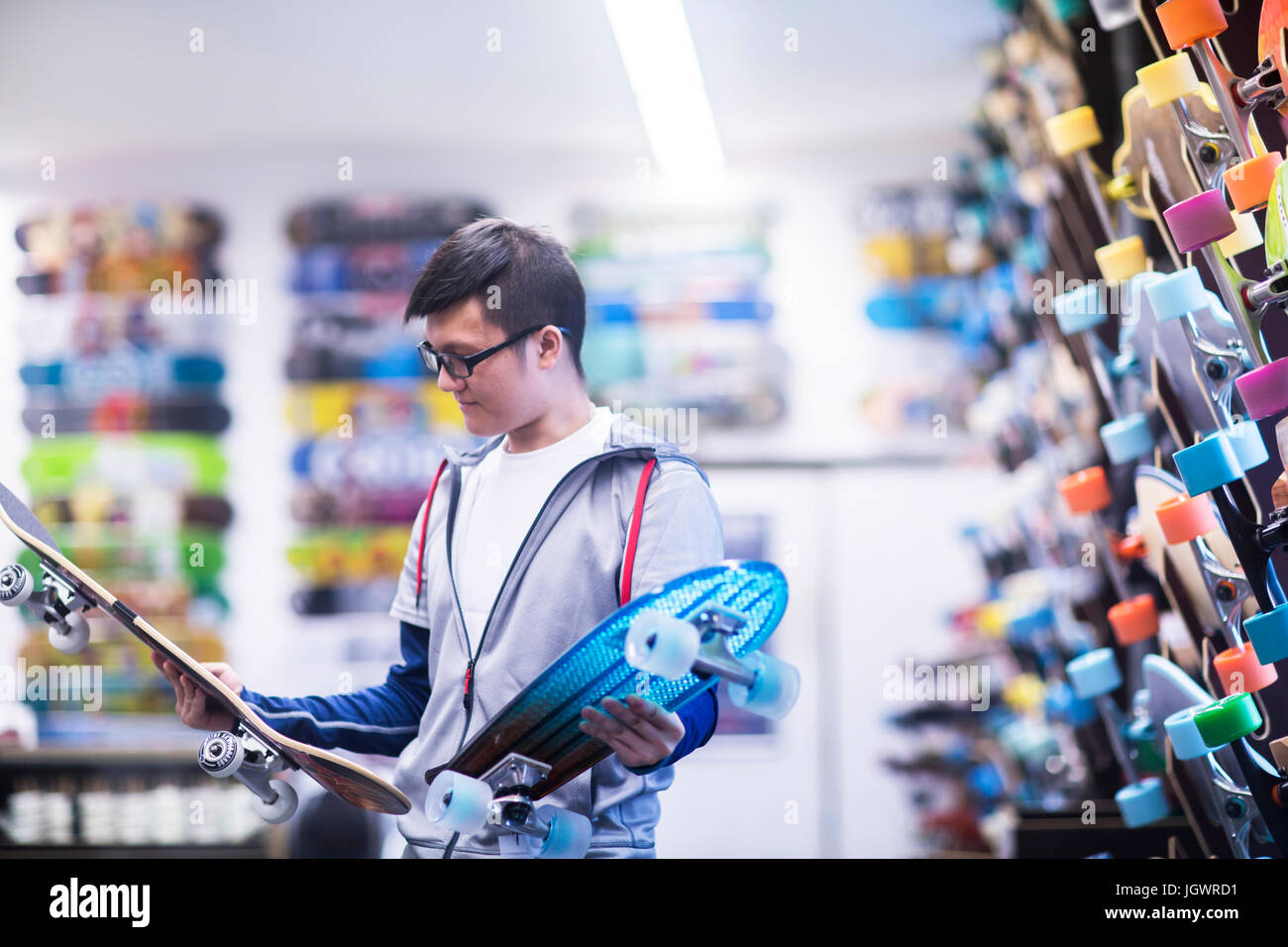 Junge männliche Skater Skateboard Skateboard Shop betrachten Stockfoto