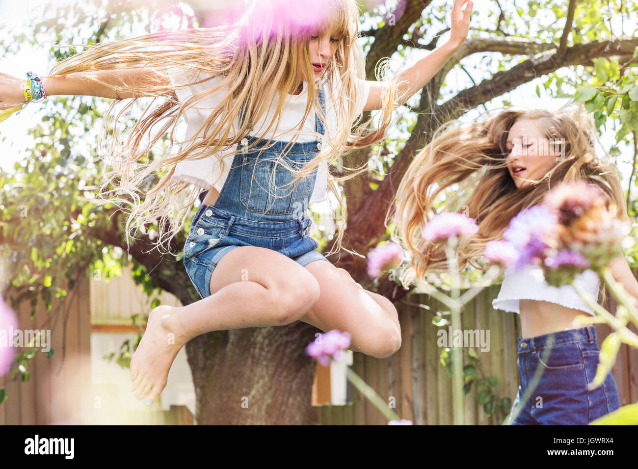 Mädchen im Garten springen in Luft Stockfoto