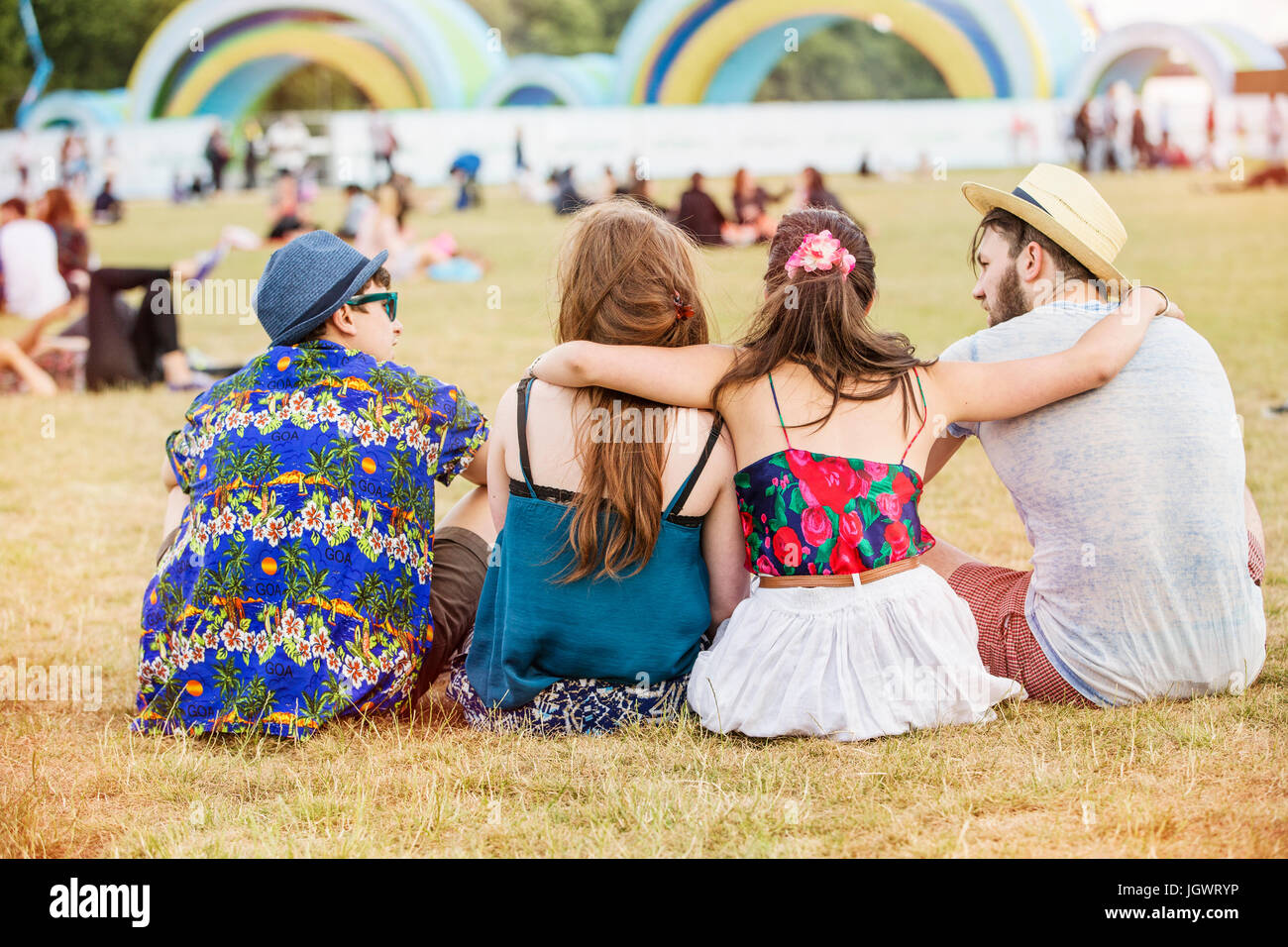 Rückansicht des Freunde sitzen auf dem Rasen beim festival Stockfoto
