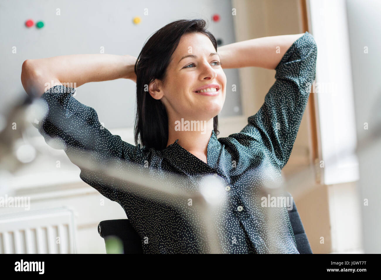 Glücklich Designerinnen mit Händen hinter dem Kopf im Kreativstudio Stockfoto