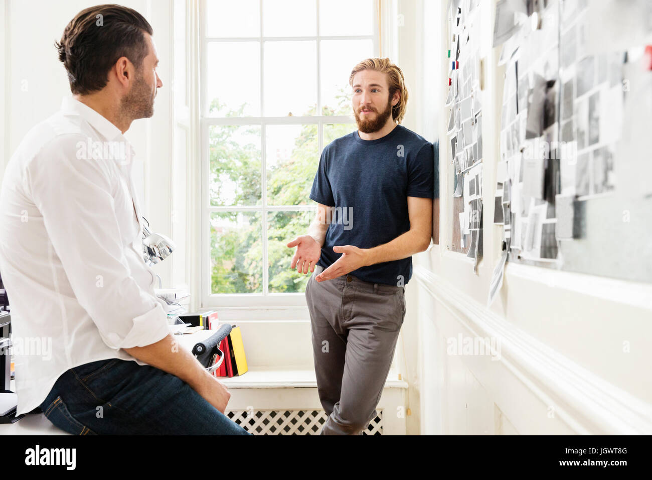 Junge männliche Designer erklären Stimmung Board Idee an Kollegen im Kreativstudio Stockfoto